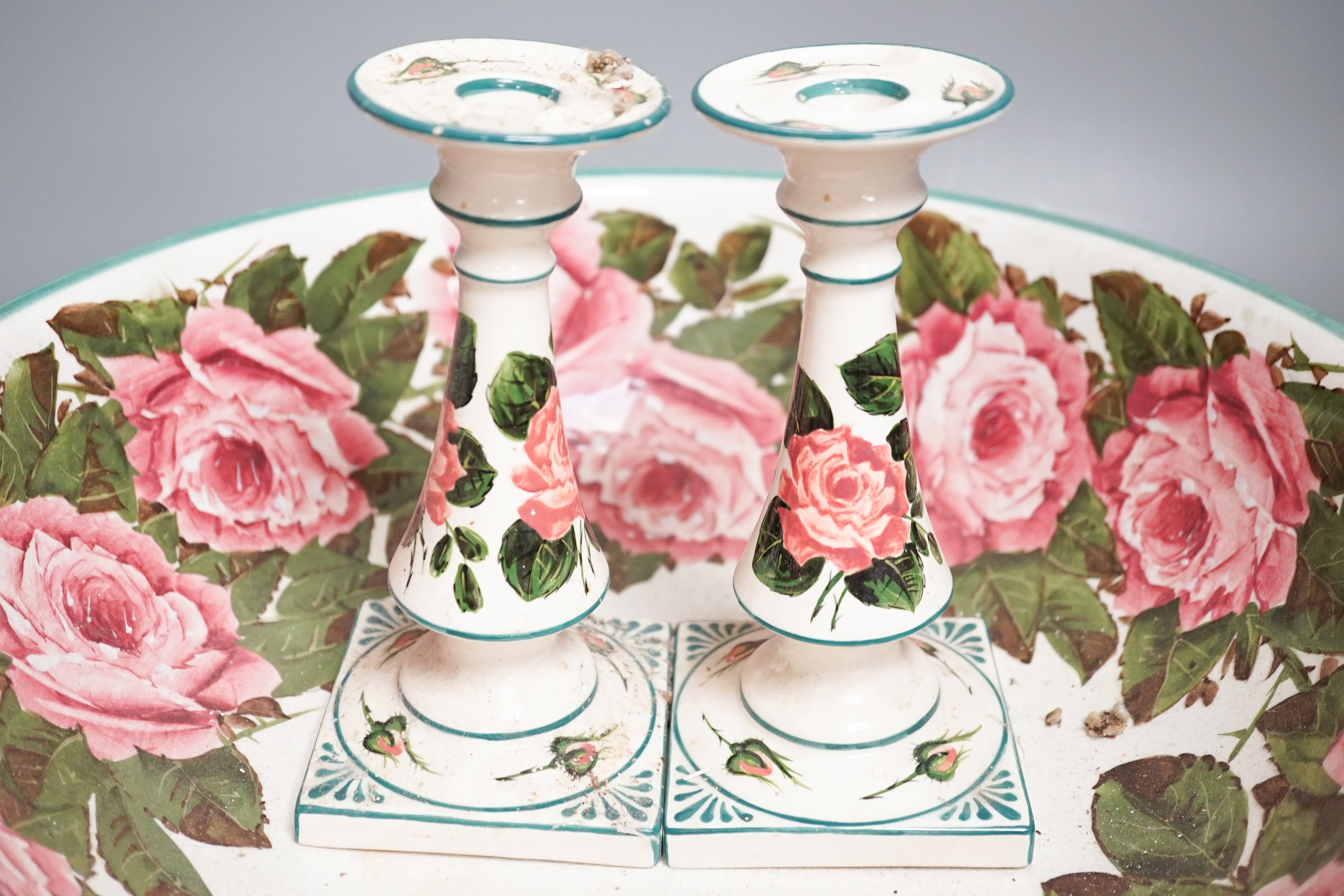 A Wemyss pottery Cabbage rose decorated toilet bowl, diameter 39cm, and a pair of Weymss style candlesticks by Griselda Hill pottery